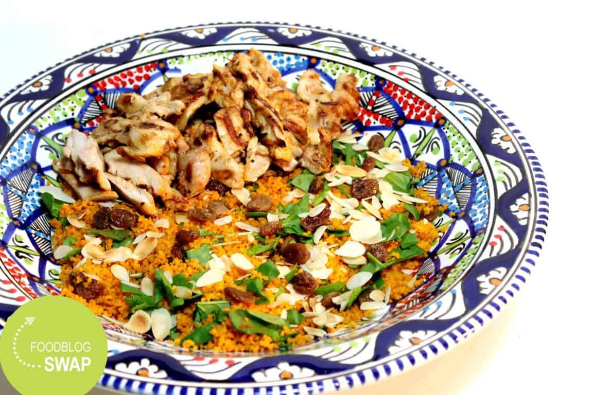 Couscous salade met kip en verse spinazie, rozijnen, amandelen en een yoghurt-limoen dressing